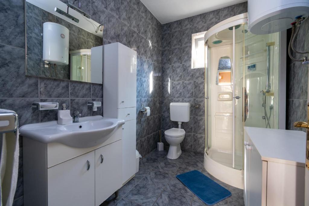 a bathroom with a sink and a shower and a toilet at Apartments with a parking space Bibinje, Zadar - 18275 in Bibinje