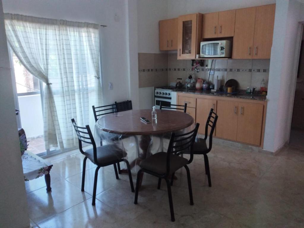 eine Küche mit einem Tisch und Stühlen im Zimmer in der Unterkunft Departamento con Balcon - Sin Aire Acondicionado - Con Ventiladores - Serena Alojamientos in Villa Constitución