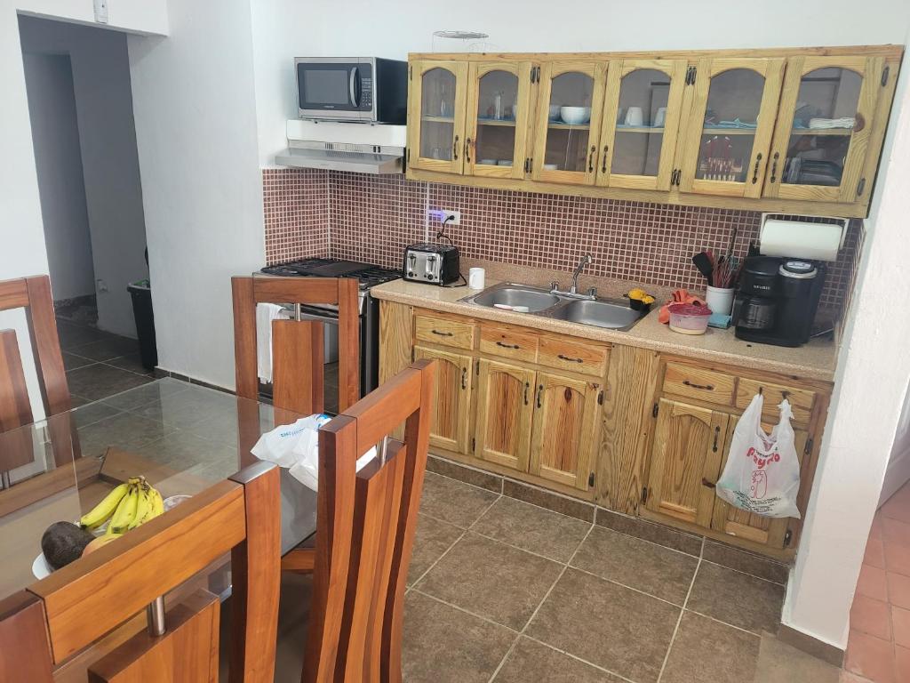 a kitchen with wooden cabinets and a sink at Sosua Apartment 4-Bedrooms in Sosúa