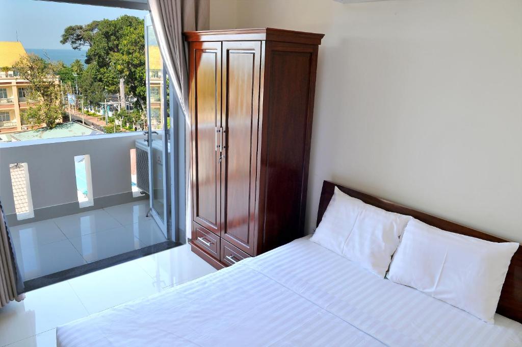 a bedroom with a bed and a large window at Lotus Apartment Hotel in Vung Tau
