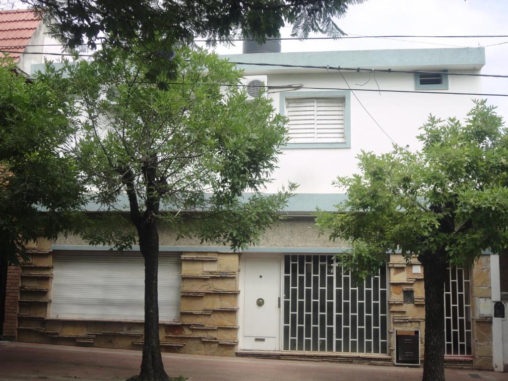 una casa blanca con garaje y dos árboles en Córdoba Alquila Alto Alberdi en Córdoba