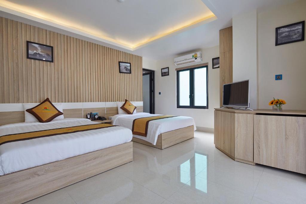sypialnia z 2 łóżkami i telewizorem z płaskim ekranem w obiekcie Sunflower Hotel w mieście Cát Bà