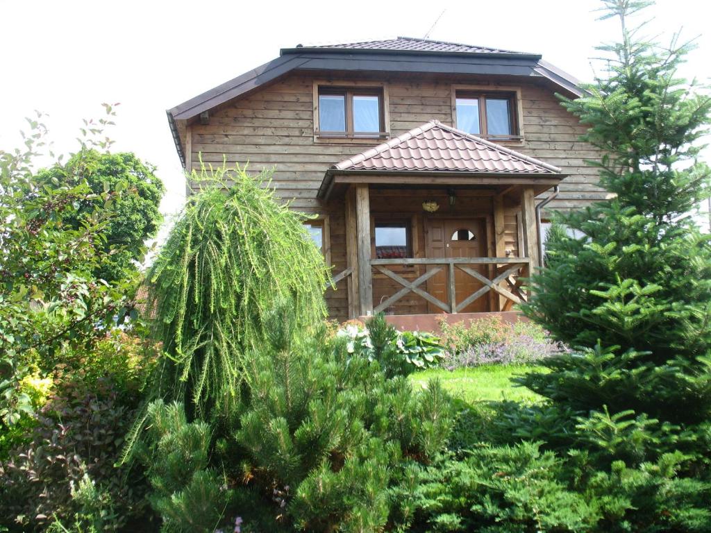 a house with a wooden door and some trees at Pod Dobrym Aniołem in Krzywonoga
