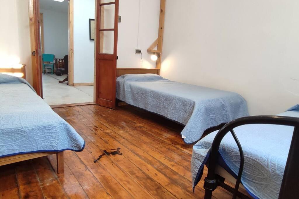a room with two beds and a wooden floor at Increíble casa y parcela en Huasco Bajo. in Huasco Bajo