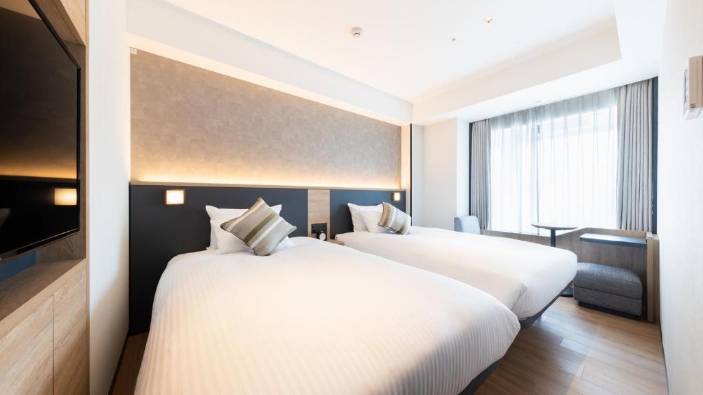 Postel nebo postele na pokoji v ubytování JR-East Hotel Mets Yokohama