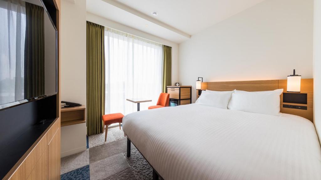 Postel nebo postele na pokoji v ubytování JR East Hotel Mets Premier Yokohama Sakuragicho