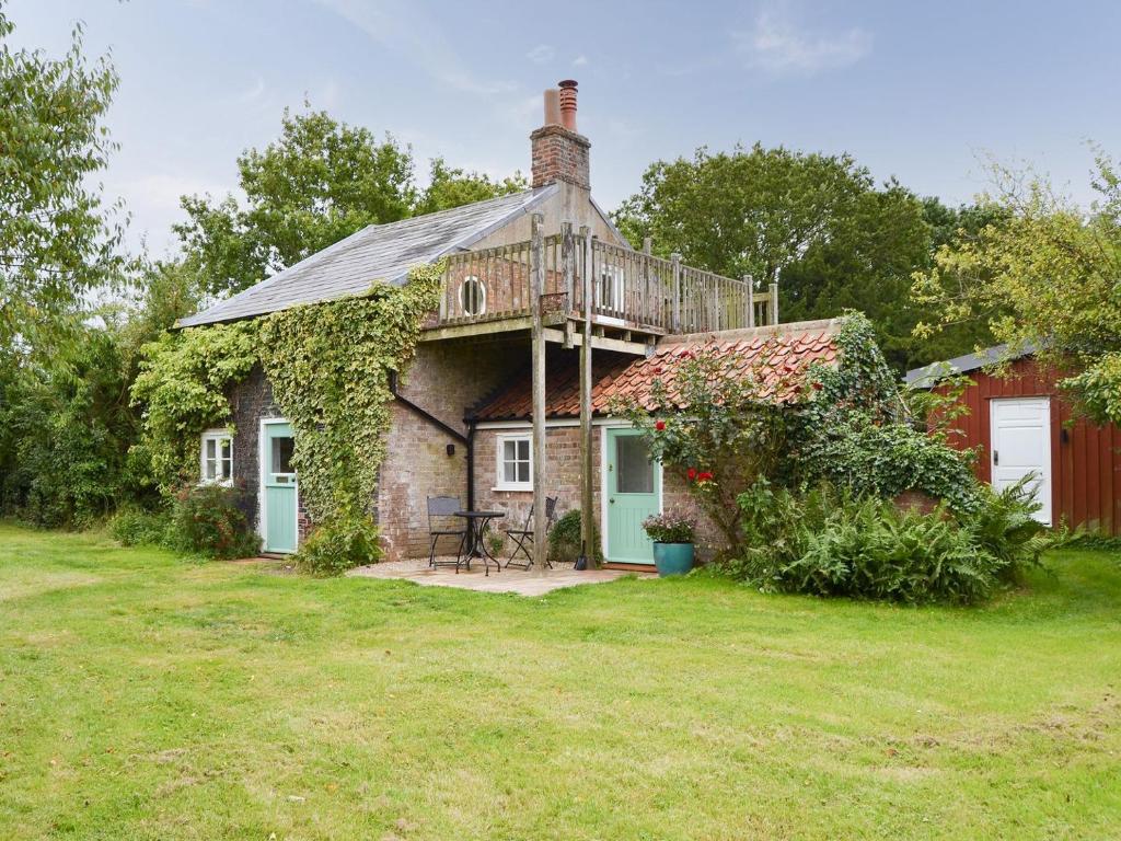 an old house with a deck on top of it at Willow Cottage in Ludham