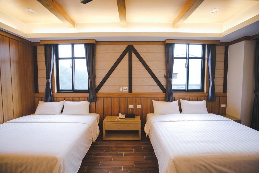 2 camas en una habitación con 2 ventanas en Gaodiyuan Tea B&B 高帝園茶業民宿, en Meishan