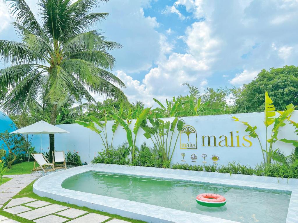 a swimming pool in front of a villa at Malis Homestay in Trà Vinh