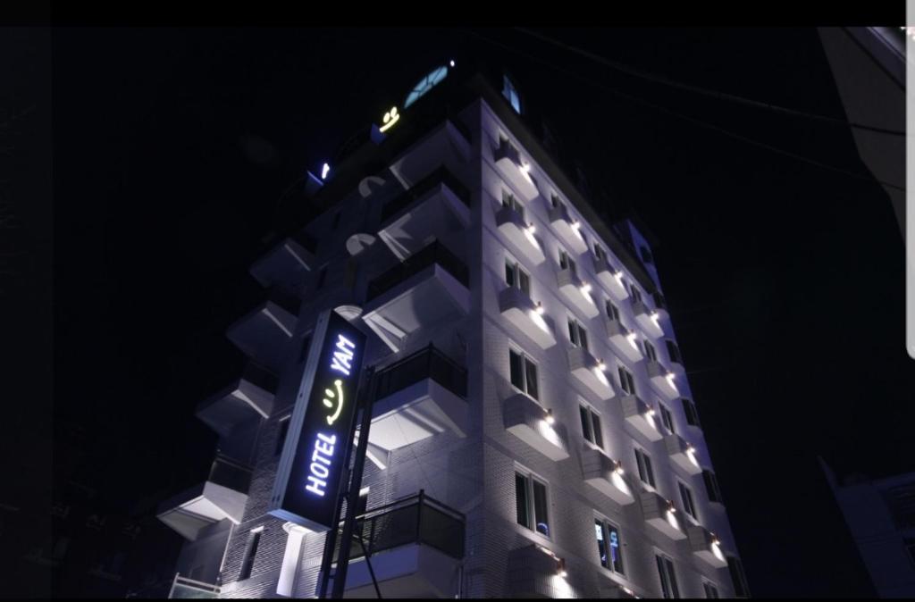 um edifício alto com um cartaz à noite em Hotel Yeosu Yam Hakdong em Yeosu