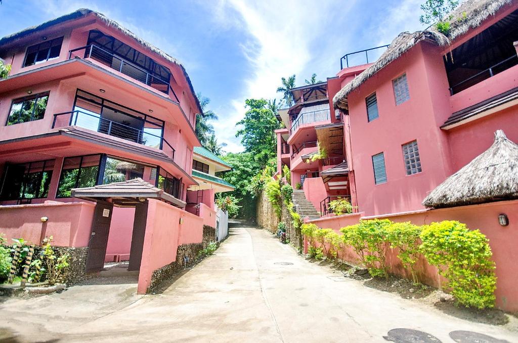 dois edifícios cor-de-rosa um ao lado do outro numa rua em Signature Boracay Punta Rosa formerly Punta Rosa Boutique Hotel em Boracay