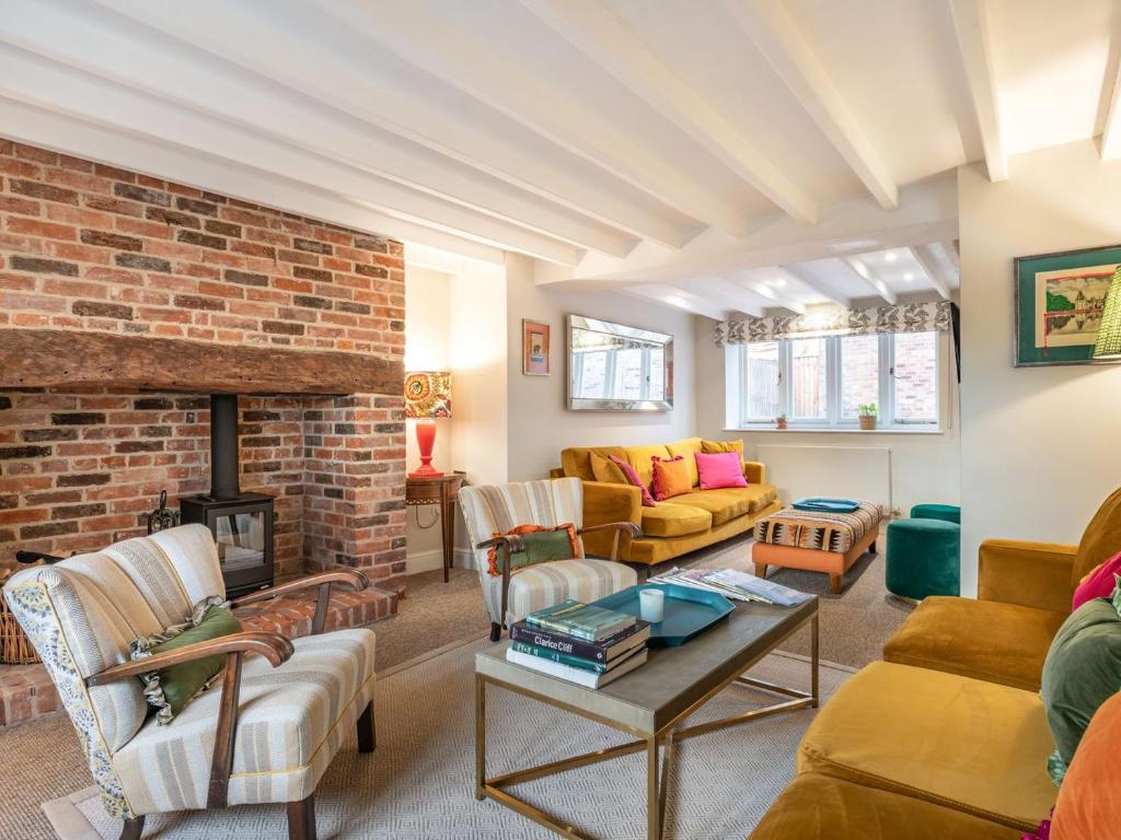 a living room with a couch and a fireplace at Orchard Farmhouse in Wighton