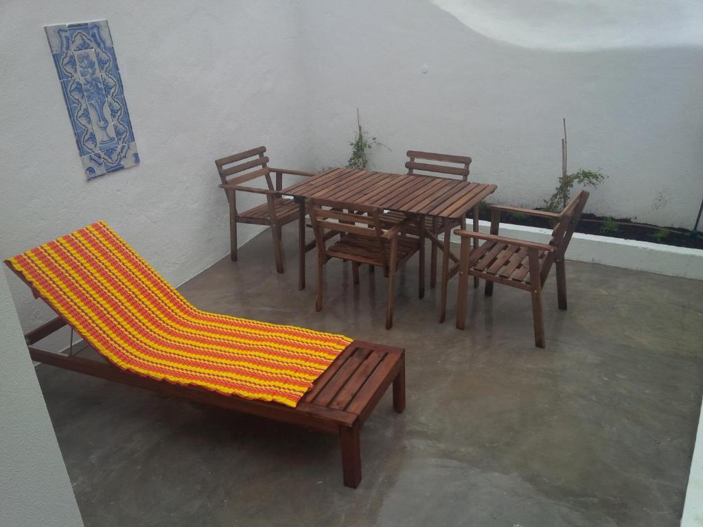 een patio met een houten tafel en stoelen bij Costa Castle Apartment in Lissabon