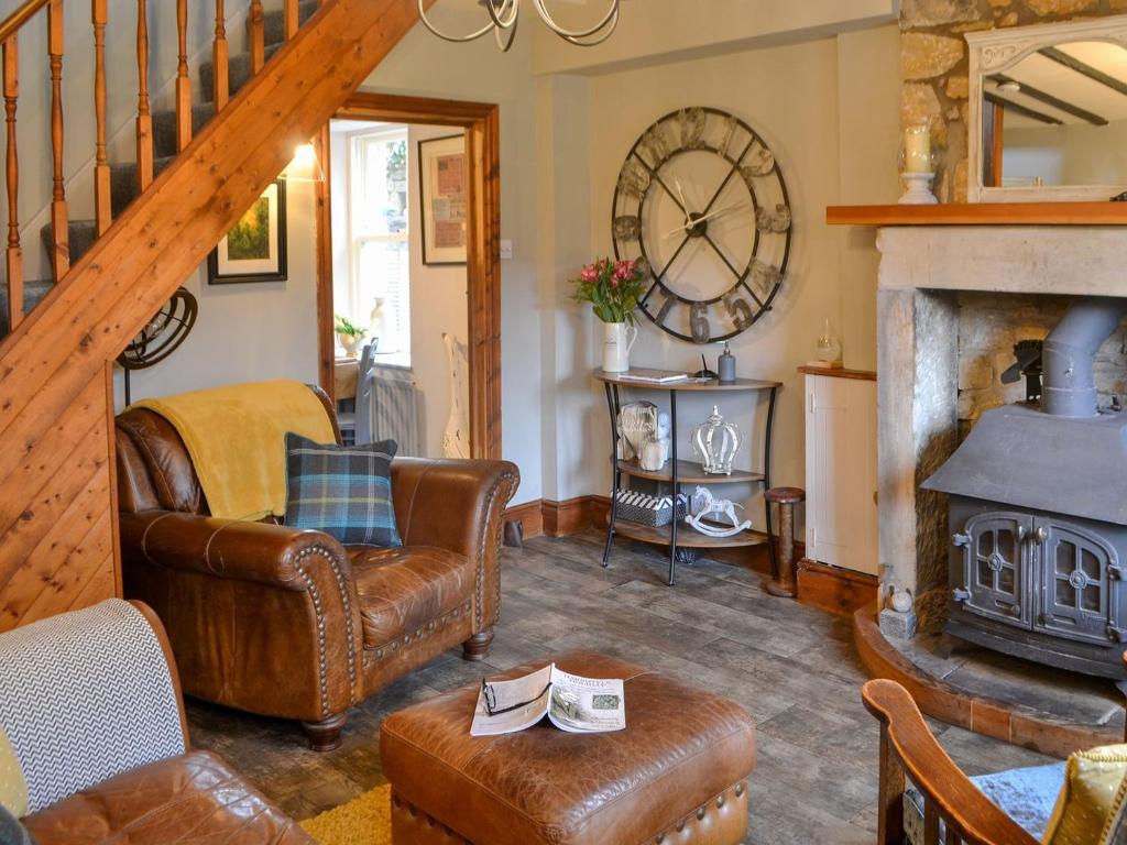 a living room with a couch and a fireplace at Townhead Cottage in Alwinton