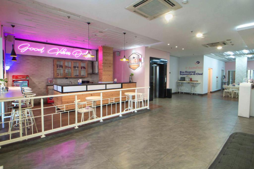 a restaurant with a bar with pink neon signs at Cleo Hotel Basuki Rahmat in Surabaya