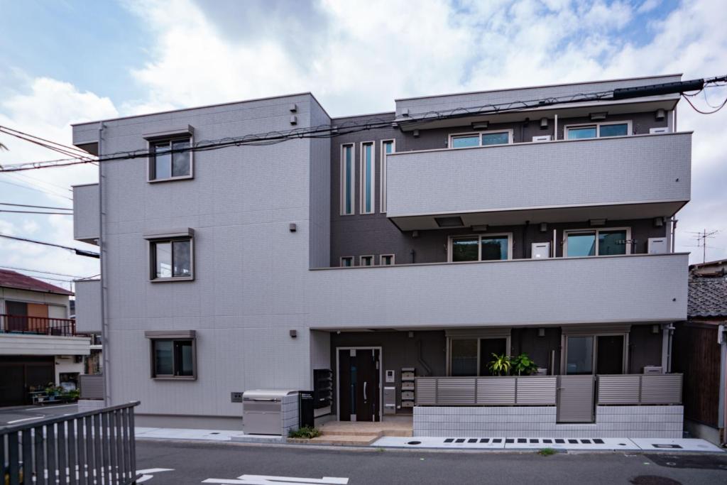um edifício branco com muitas janelas em 震雲マンション105 em Osaka