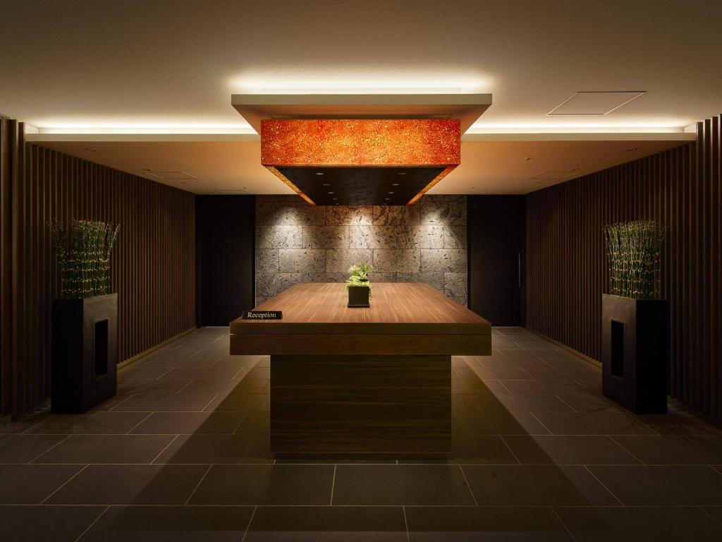 a lobby with a desk in the middle of a room at Villa Fontaine Grand Osaka Umeda in Osaka