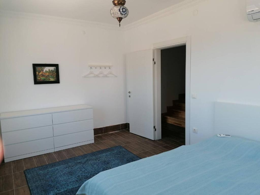 a white bedroom with a bed and a dresser at Private villa with pool and sauna in Altınkum