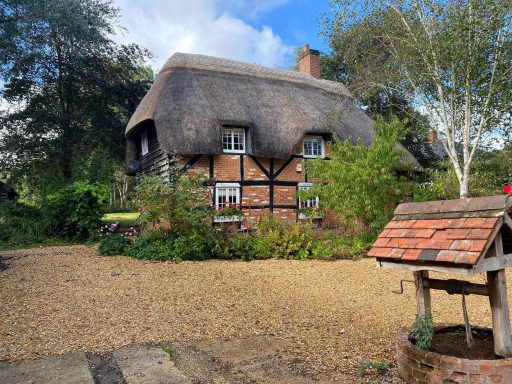 an old fashioned house with a thatched roof at Dairy Farm in Sherfield English
