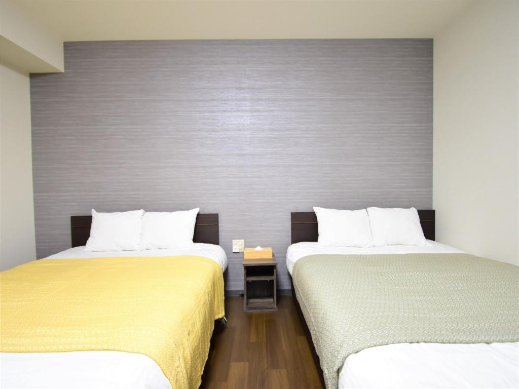 two beds in a hotel room with two beds sidx sidx sidx at Regariain - Vacation STAY 85012 in Okayama