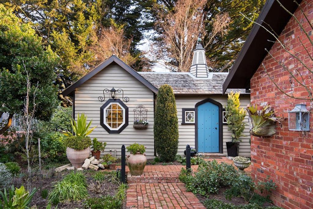 una pequeña casa blanca con una puerta azul en Musk Farm Studio, en Bullarto
