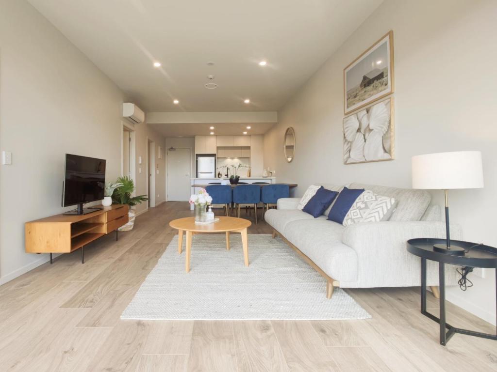 uma sala de estar com um sofá e uma mesa em Luxurious 2 bedroom apartment Free secure parking em Auckland