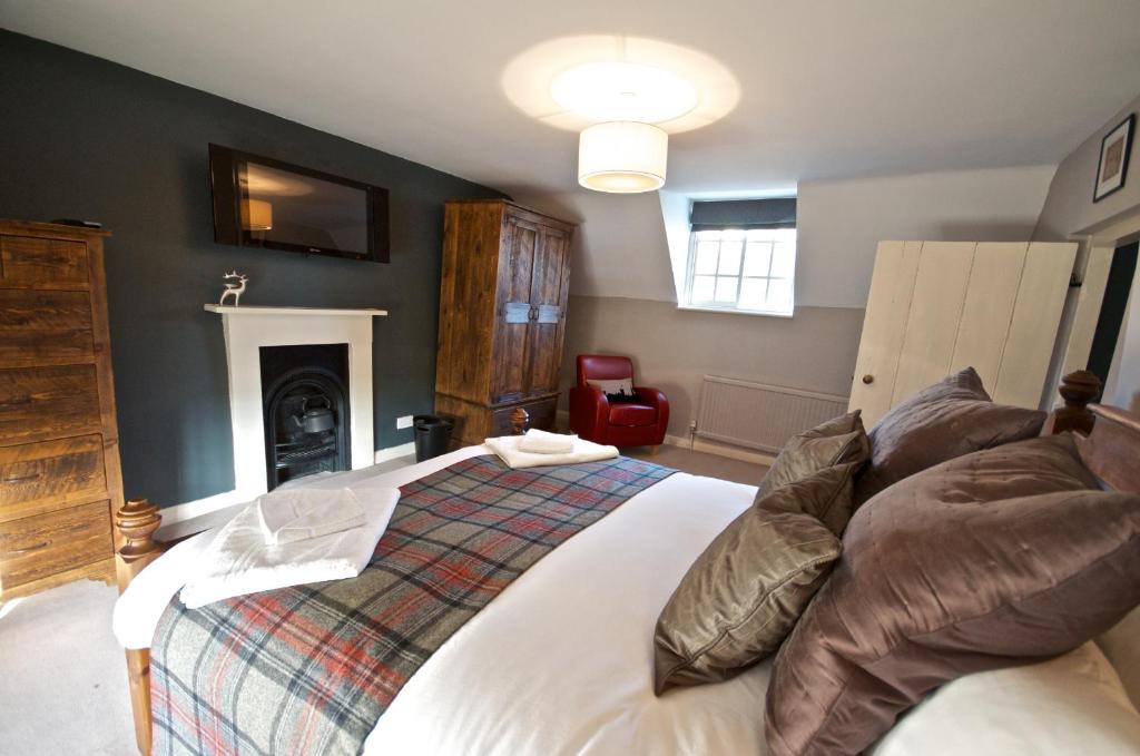 um quarto com uma cama grande e uma lareira em Stunning Yew Tree Cottage em Westow