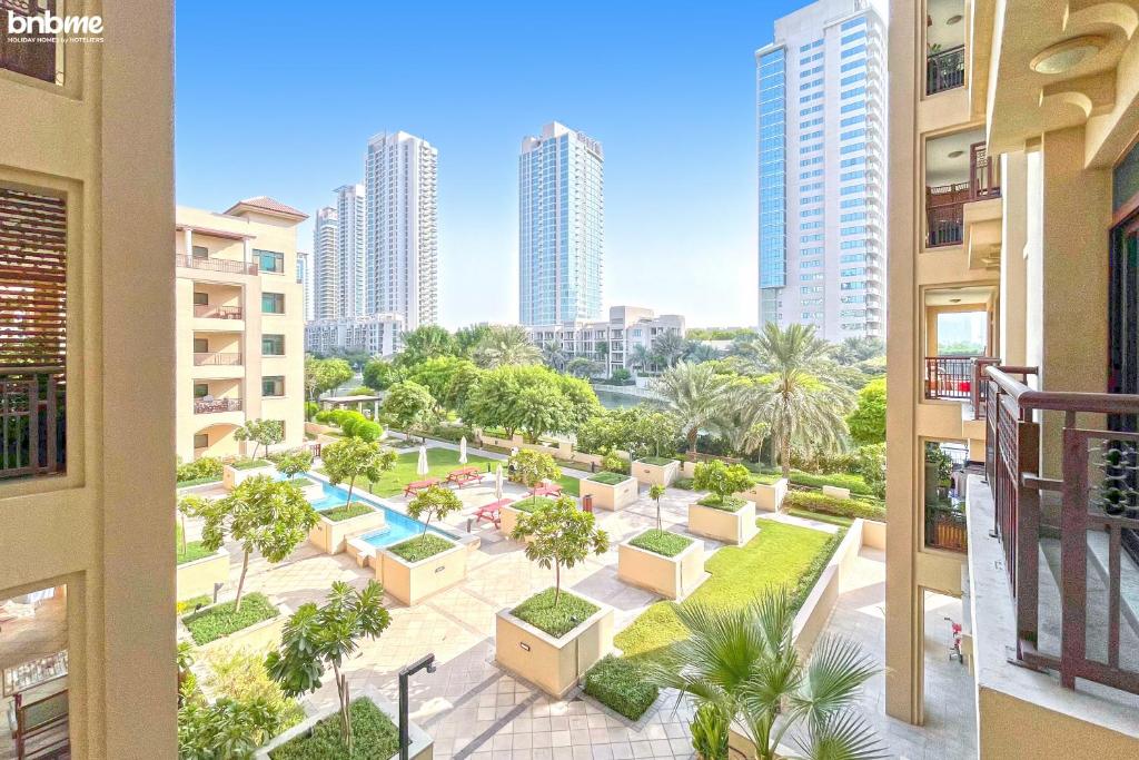 uitzicht op een park in een stad met hoge gebouwen bij bnbmehomes - 2 BR Stunning Lake Views in Al Turia - 205 in Dubai