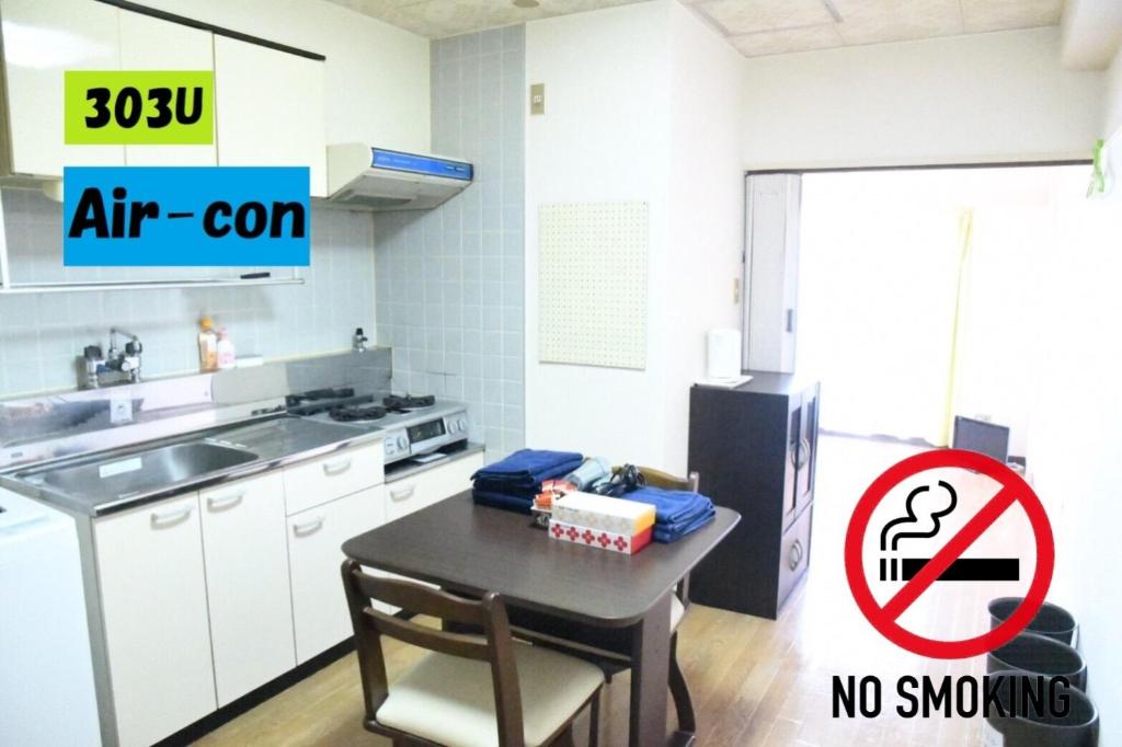 a kitchen with a table and a refrigerator with a no smoking sign at Ueda Building - Vacation STAY 8552 in Asahikawa