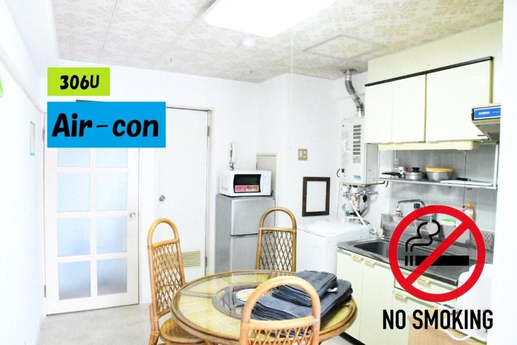 a kitchen with a table and chairs with a no smoking sign at Ueda Building - Vacation STAY 8554 in Asahikawa