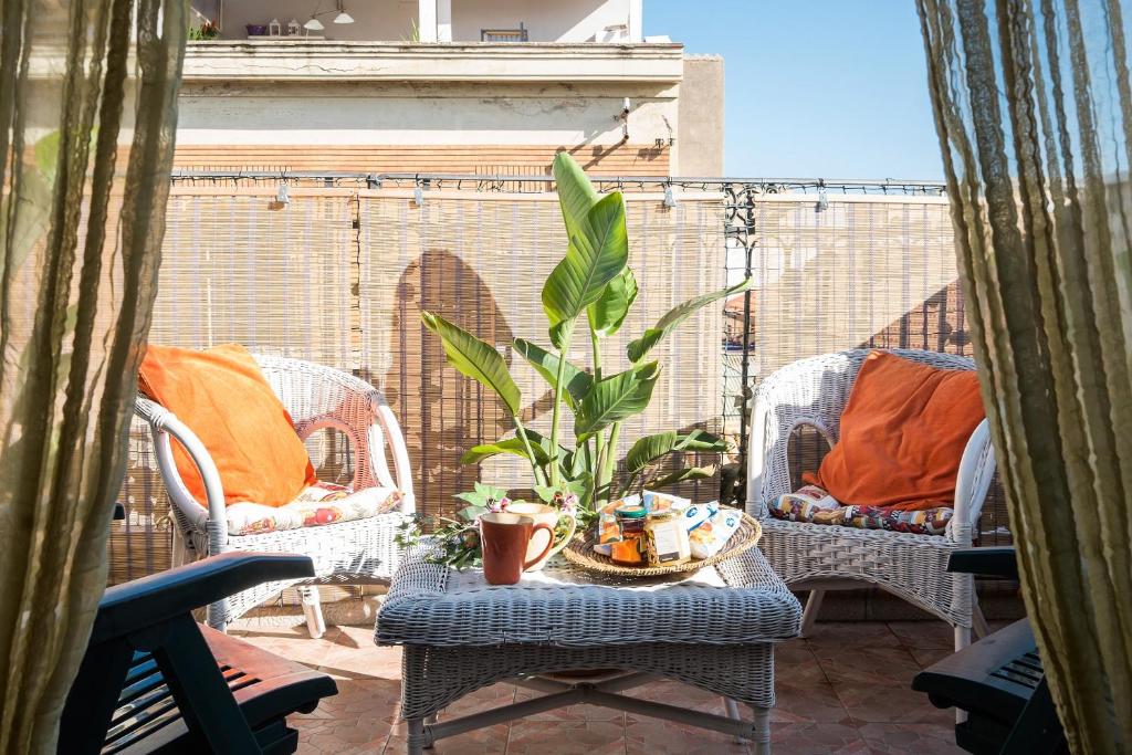 eine Terrasse mit Stühlen und einem Tisch mit Pflanze in der Unterkunft La Terrazza di Massimo in Palermo