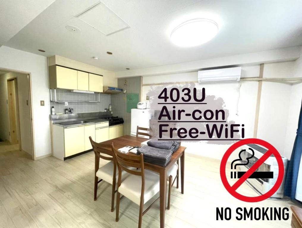 a kitchen with a table and a sign that says air con free wifi at Ueda Building - Vacation STAY 11774 in Asahikawa