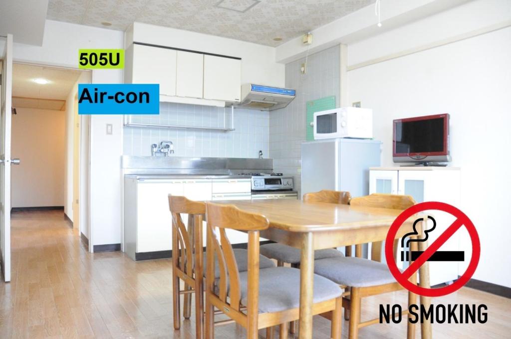 a kitchen with a table with chairs and a no smoking sign at Ueda Building - Vacation STAY 8560 in Asahikawa