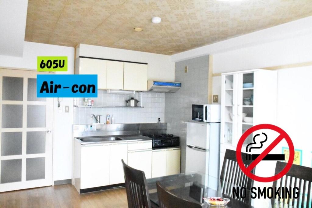 a kitchen with white cabinets and a table with chairs at Ueda Building - Vacation STAY 8562 in Asahikawa