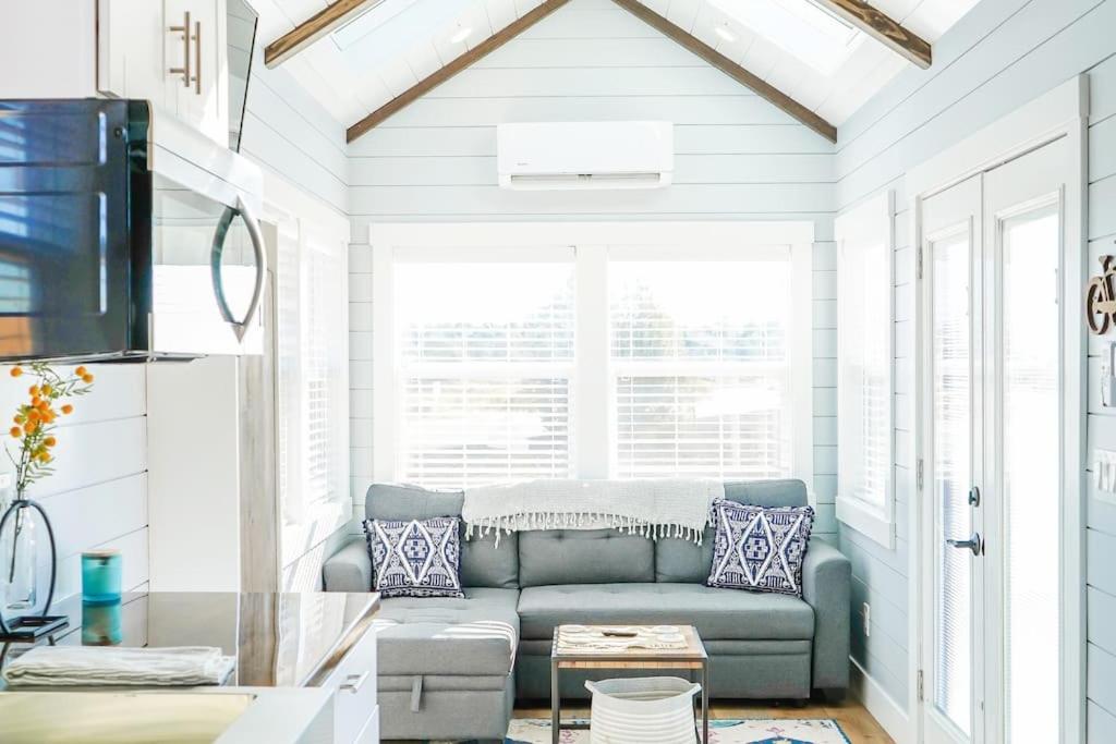 uma sala de estar com um sofá em frente a uma janela em Charming Tiny Home with private deck and bbq em Apple Valley