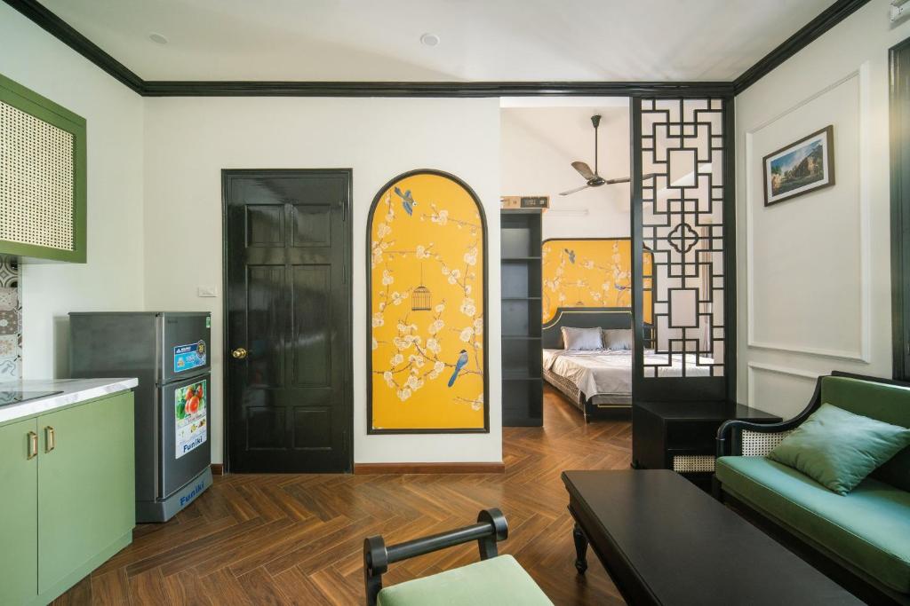 uma sala de estar com um sofá e um quarto com uma cama em Impresso Home & Cafe Hanoi em Hanói