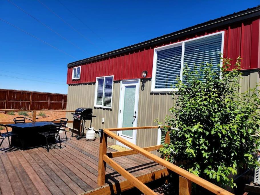 una terraza con mesa de picnic y un edificio en Peaceful Tiny Home with private deck-fire pit-bbq, en Apple Valley