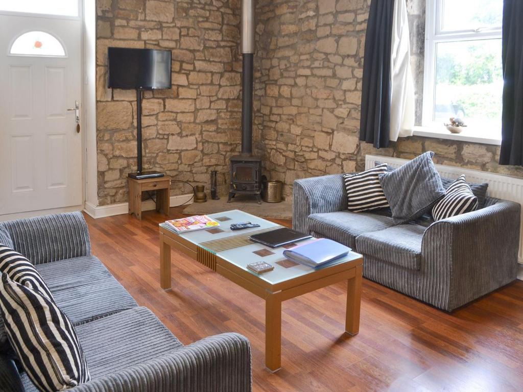 a living room with two chairs and a coffee table at Stable Cottage - Uk3285 in Guyzance