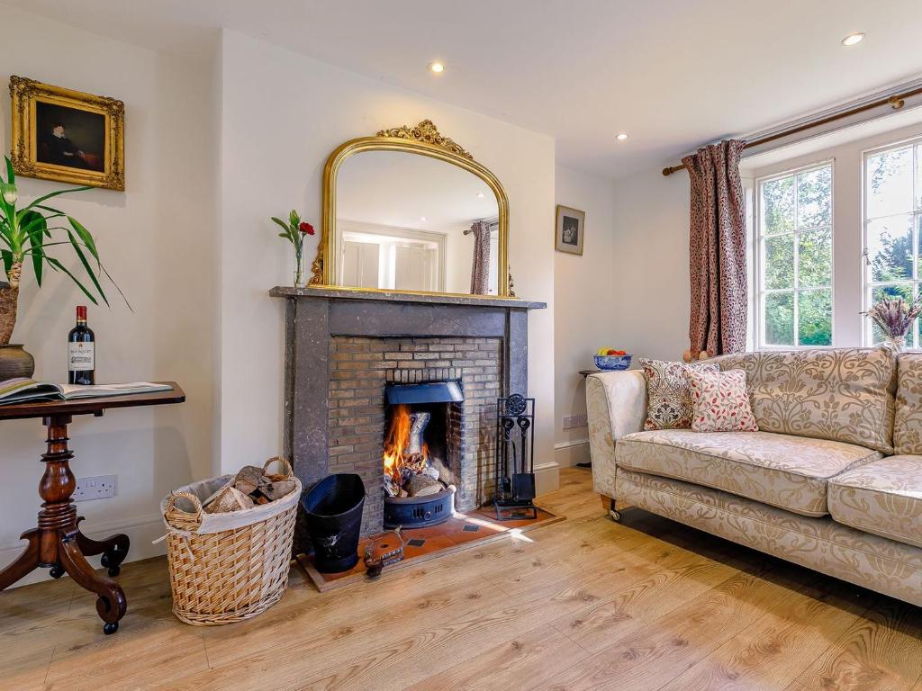 a living room with a fireplace and a couch at Gardeners Cottage - Uk35774 in Fulbeck
