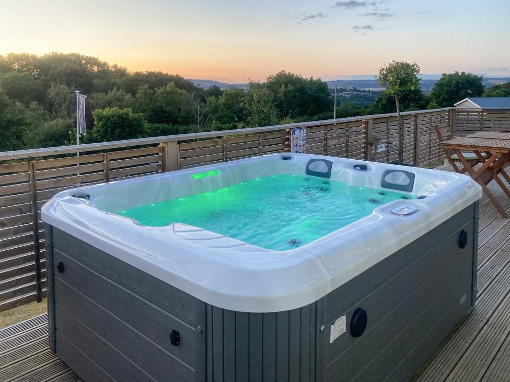 a hot tub on the deck of a house at Lookout Lodge-uk36700 in Newton Abbot