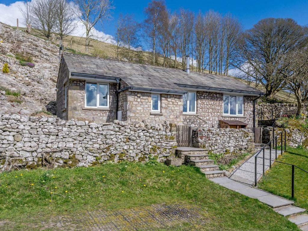 a stone house with a stone wall at Limecroft in Malham