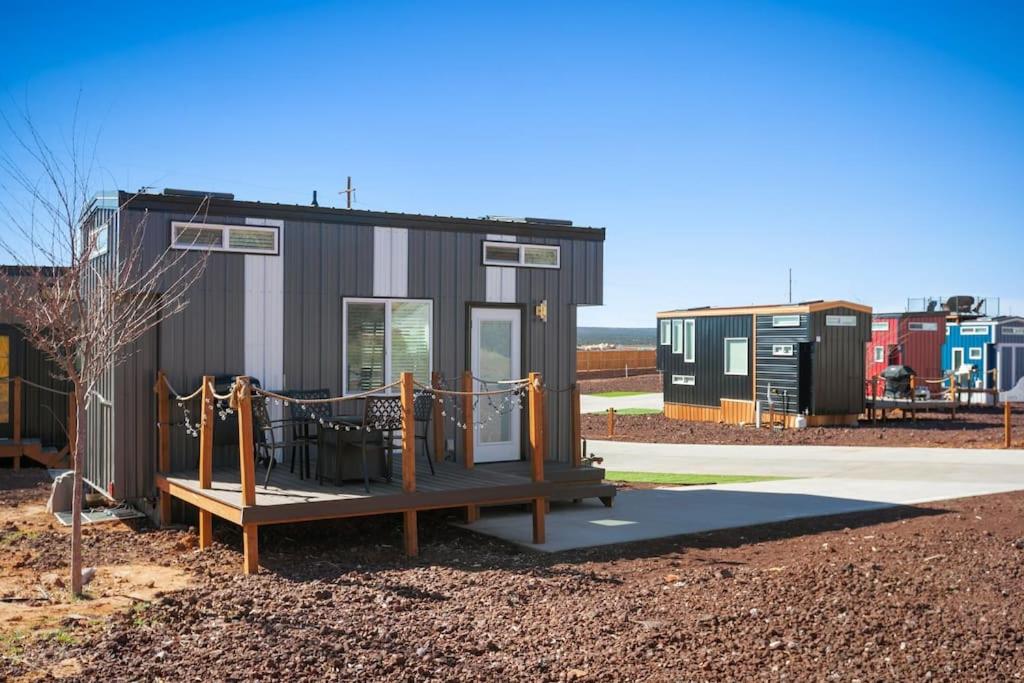 a tiny house with a porch and a playground at Under The Sea Tiny Home in Apple Valley