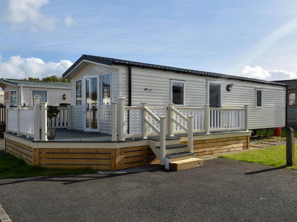 a mobile home with a porch and a deck at Windemere Lodge in Morecambe