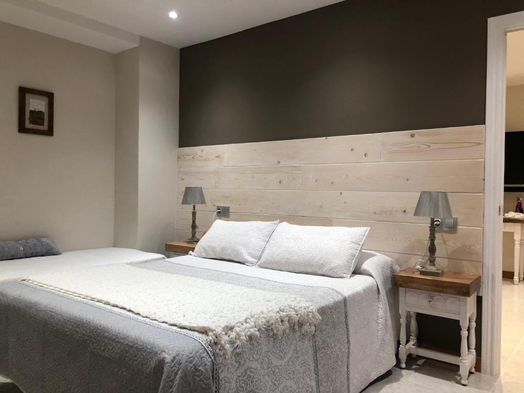 a bedroom with a bed and a wooden wall at Hotel Apartamentos Barrau in Villanova