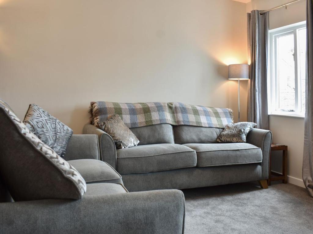 a living room with a couch and a chair at 6 Twentyman Court in Keswick