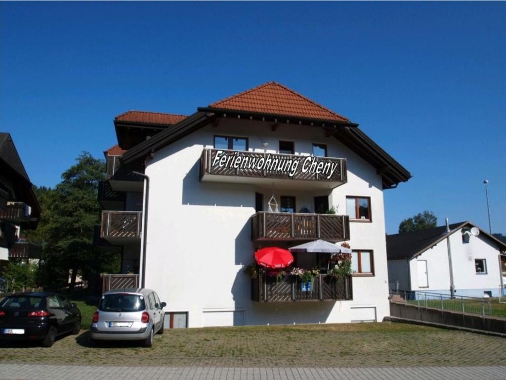 Un bâtiment blanc avec un panneau. dans l'établissement FeWo Cheny in Titisee, à Titisee-Neustadt