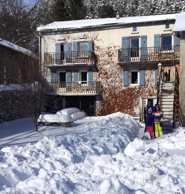 Un groupe de personnes debout dans la neige devant un bâtiment dans l'établissement Maison Sarda, à Formiguères