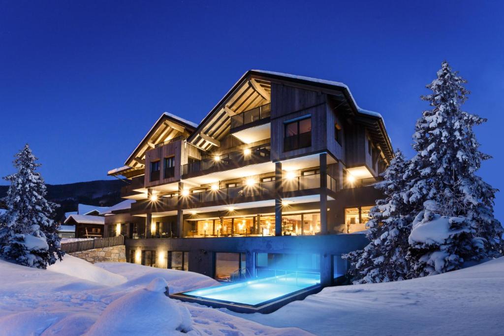 a large house in the snow at night at THE MATTHEW - Copper Lodge in Wagrain