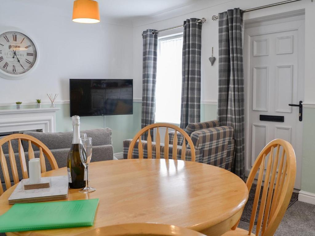 a dining room with a wooden table and chairs at Bramble Cottage in Brampton