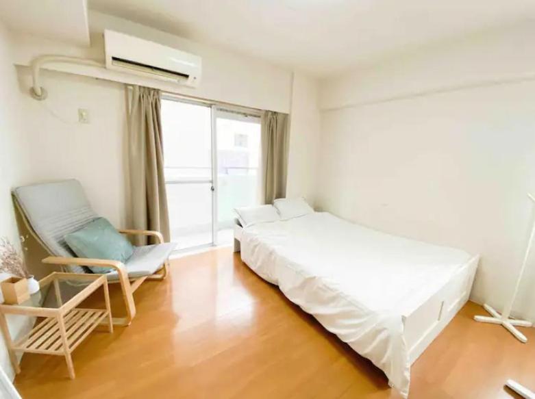 um quarto com uma cama, uma cadeira e uma janela em Urban Core Shikano 501 em Tóquio